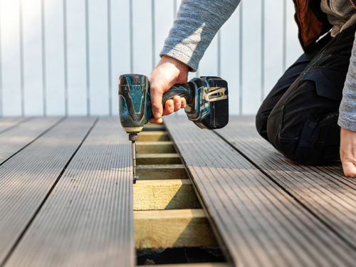 contractor hand close up with drill repairing deck floor cincinnati oh
