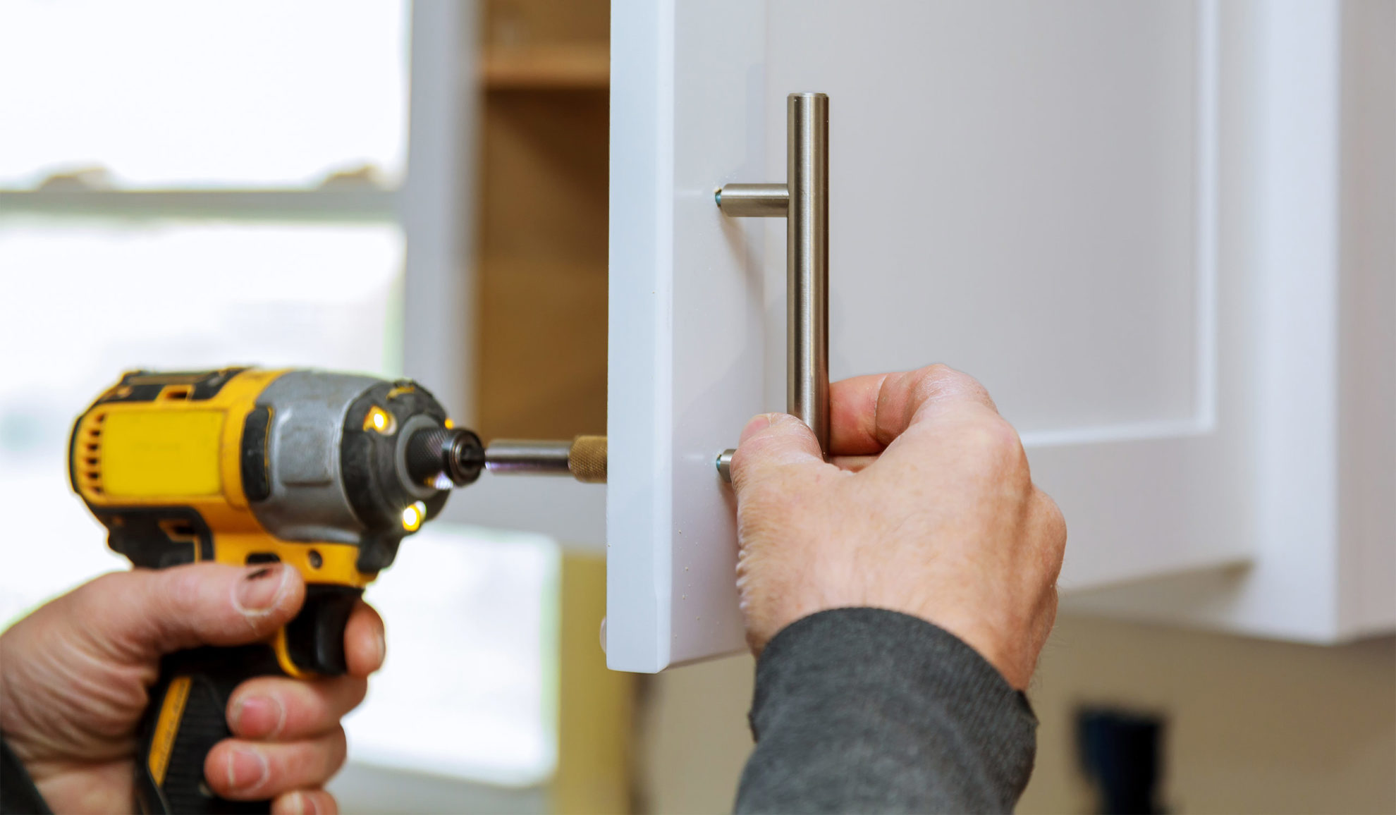 handyman close up with drill installing new cabinet knob cincinnati oh