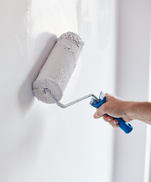 handyman hand close up painting a white wall with paint roller cincinnati oh