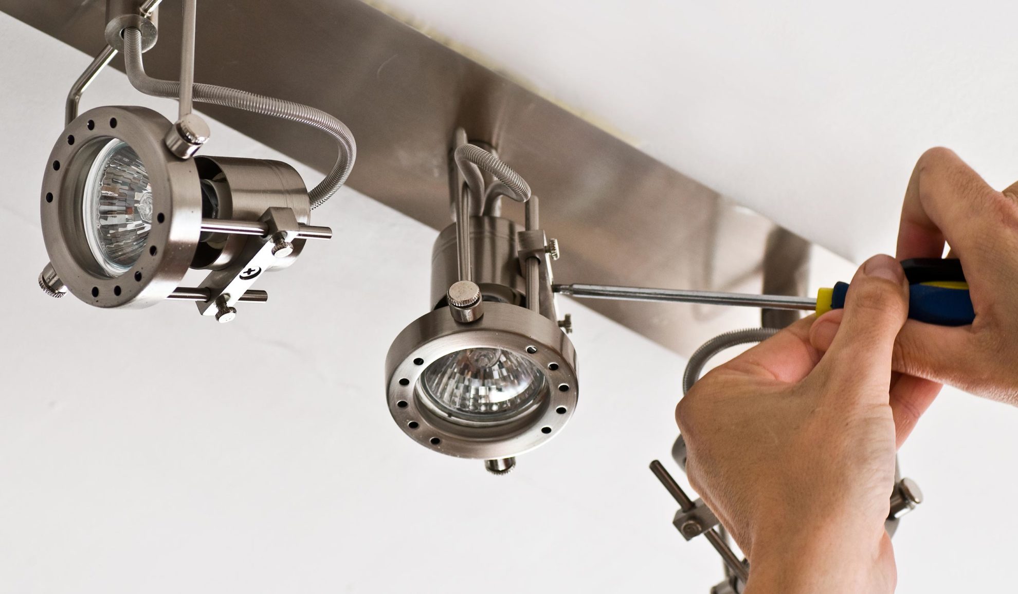 handyman hand close up with screwdriver repairing lighting fixture cincinnati oh