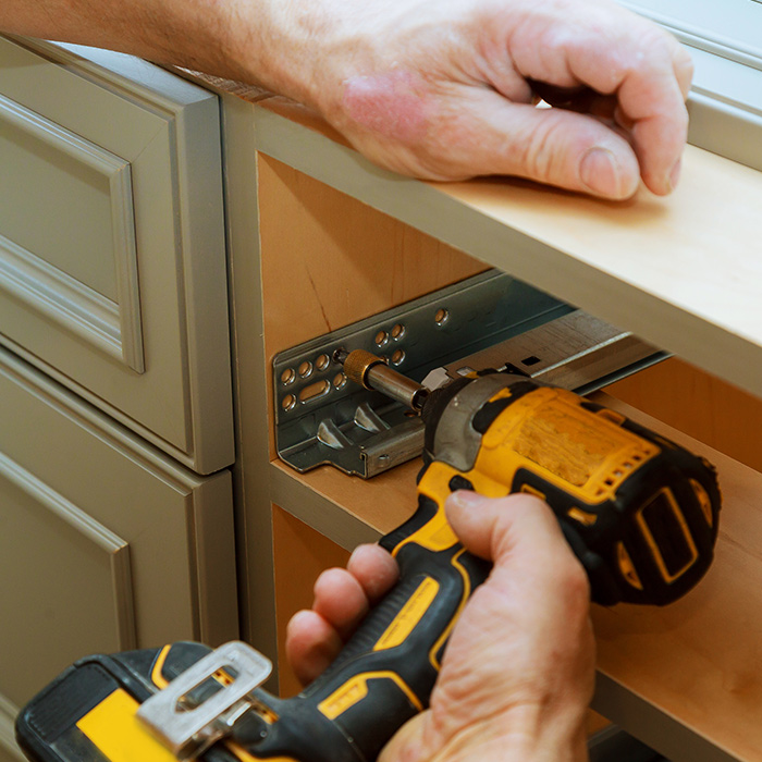 handyman hands with drill replacing wooden cabinets hardware cincinnati oh