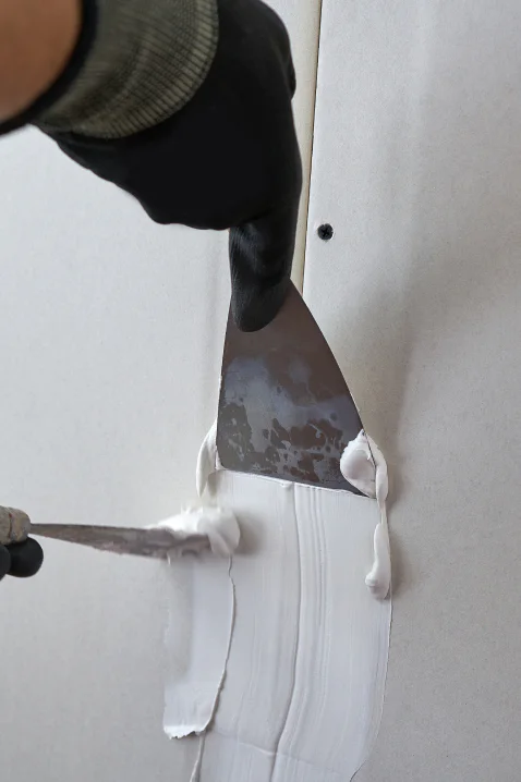 drywall repair contractor using spatulas to repair a drywall cincinnati oh